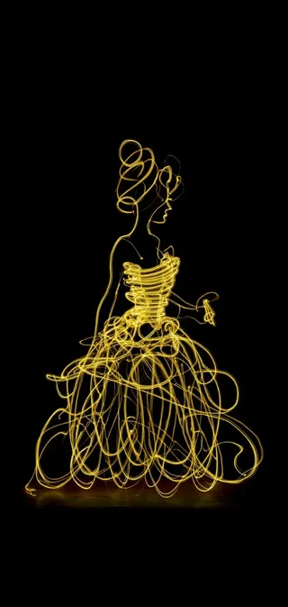 Silhouette of a woman in a golden light-painted gown against a black background, created using light painting technique.