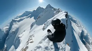 A snowboarder in black tactical gear speeding down a snowy mountain, kicking up a huge powder avalanche behind them, with harsh sunlight and ice crystals in the air.