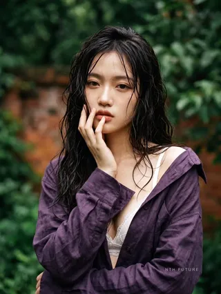 Close-up cinematic portrait of an ethereal Asian woman with wet hair and expressive eyes, surrounded by blurred green foliage.