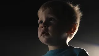 Two figures illuminated by spotlights on a dark stage, facing each other in a tense confrontation.
