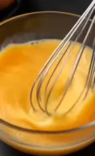 Close-up shot of a giant, golden-brown Indonesian egg roll being seasoned dramatically.