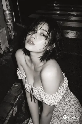 Monochrome high-angle portrait of a short-haired woman near stone steps under soft lighting.