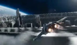 A futuristic fighter jet in a high-speed chase, diving through the complex, massive, and collapsing interior machinery of a ring world.