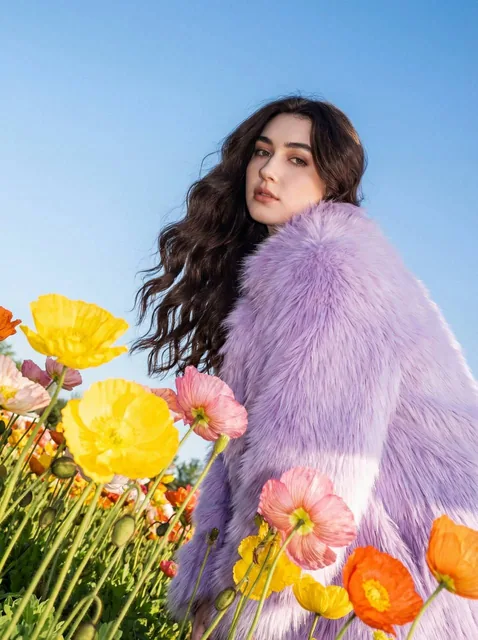 Use this photo attached to create a striking outdoor fashion portrait set in a vibrant flower field during daylight, cap