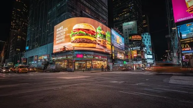 Ultra-realistic cinematic night cityscape inspired by Times Square, New York. A wide-angle street-level view of a busy u