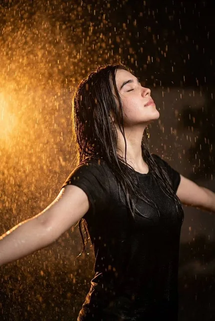 Ultra realistic cinematic portrait of a 32-year-old young woman standing in heavy rain at night, arms open wide and face