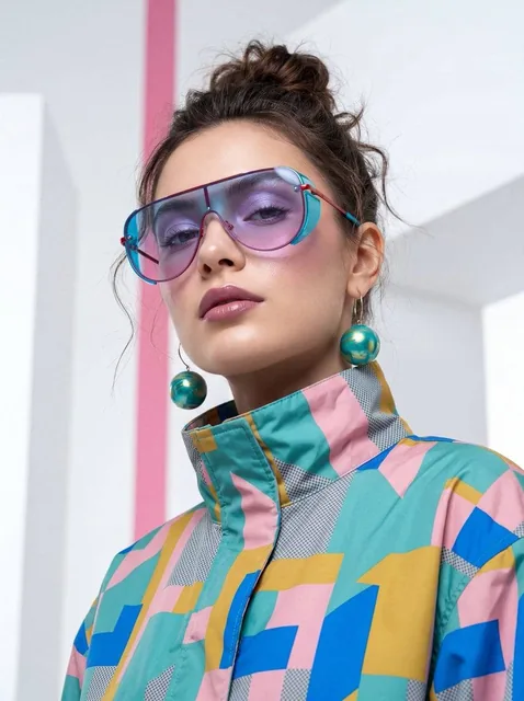 A high-fashion, cinematic portrait of a young woman with a sharp, modern aesthetic. She is positioned in a low-angle sho