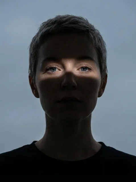 Close-up portrait of a woman (Same face as reference image)looking directly at the camera. Her face and neck are mostly