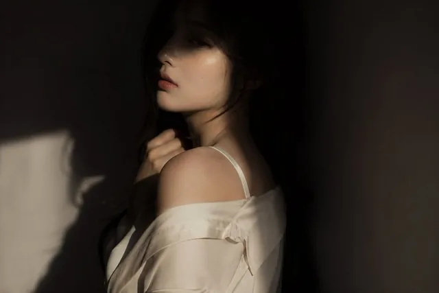 editorial portrait, Korean female idol, subtly sensual outfit: silk shirt or soft fabric top, slightly loose, elegant an