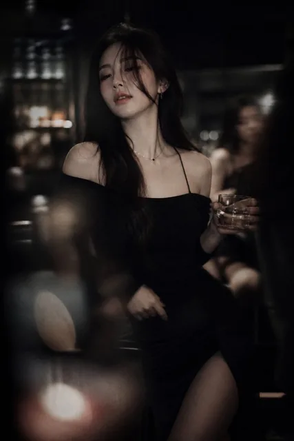 Low-light cinematic portrait, telephoto lens compression, shallow depth of field, intentional soft focus and motion blur