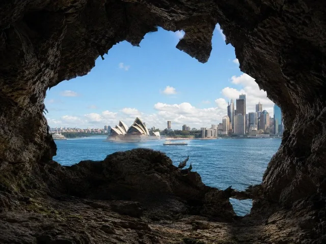 Create a photorealistic image viewed from inside a natural rocky cave looking outward. The cave opening should be clearl