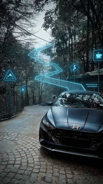 A modern charcoal-grey hatchback sits stationary on a dark, wet cobblestone road nestled within a dense, shadowed forest