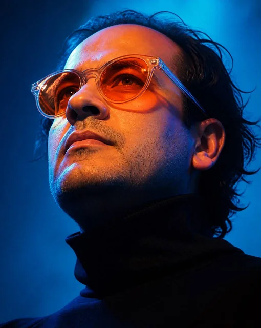 A man, likely in his early thirties with facial proportions, structure, and overall appearance inspired by the reference