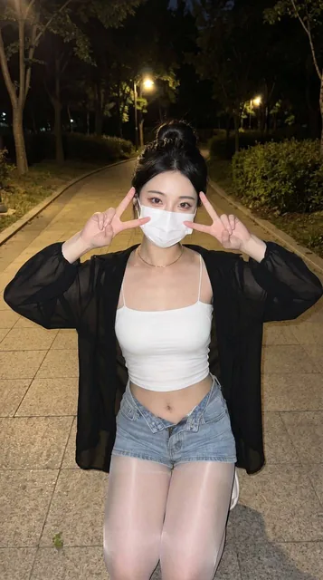 Nighttime park path captured with phone flash, a curvy hourglass young adult Asian woman kneeling and sitting in the cen