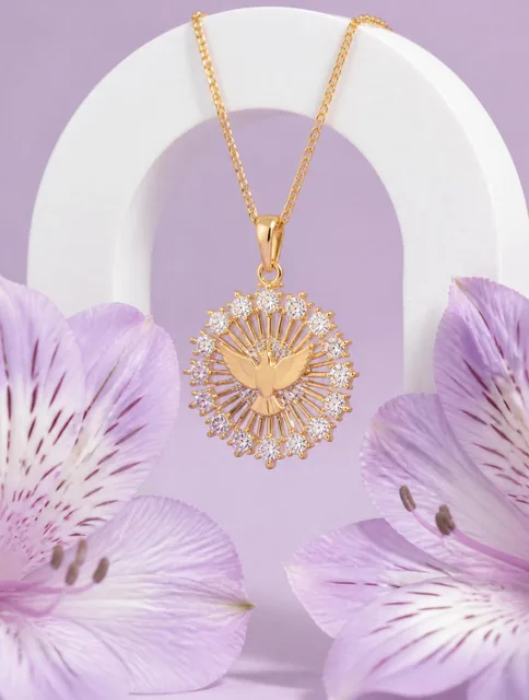 A delicate gold pendant featuring a central dove motif surrounded by a sunburst of radiant lines and brilliant-cut clear
