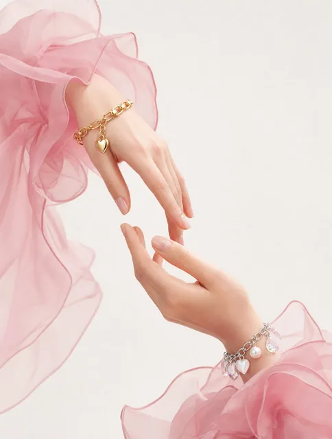 Two delicate hands reach toward each other in a graceful, symmetrical arrangement against a clean, minimalist off-white