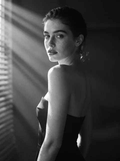 A hyperrealistic 8k black and white cinematic mid shot portrait of a beautiful woman with natural freckles and soft full