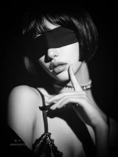 A black-and-white photograph of an elegant woman with a blindfold over her eyes, holding one finger to her lips in a gesture of silence, set against soft lighting that creates a mysterious and high-fashion minimalist aesthetic with hyper-realistic details.