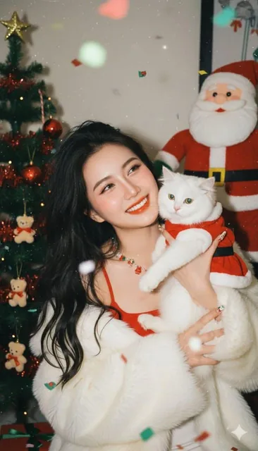 A young Asian woman with loose black curls and a pouty expression, wearing a red spaghetti-strap top and fluffy white faux-fur coat, making a peace sign with both hands in a Christmas party scene with a tree, Santa plush, and falling confetti, captured in a vintage Y2K direct-flash photo style with