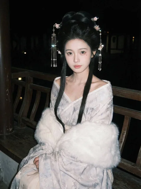 A detailed portrait of a character in an ancient garden night scene, sitting on a wooden bench with a soft white fur shawl wrapped around, featuring a high ancient-style bun with ornate hairpins, under dim lighting with a slight upward camera angle.