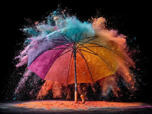 A high-speed flash photography capture of an explosion with colorful particles radiating outward in frozen chaos against a deep black background, conveying dynamic energy and impactful advertising visuals.