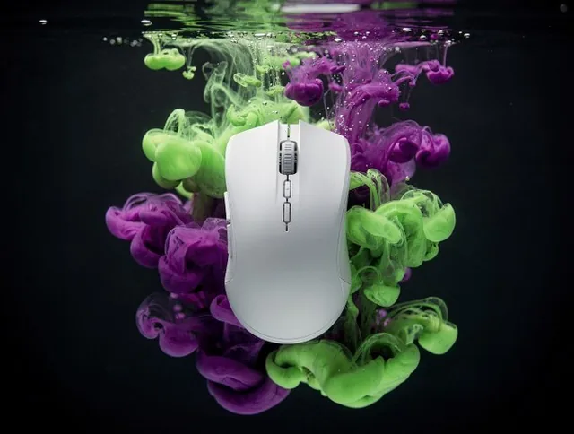 A product is the central focus, surrounded by billowing clouds of ink in water. Vibrant, organic fluid shapes and tendrils swirl around it in a hypnotic motion, captured in a studio shot with an abstract expressionist aesthetic.