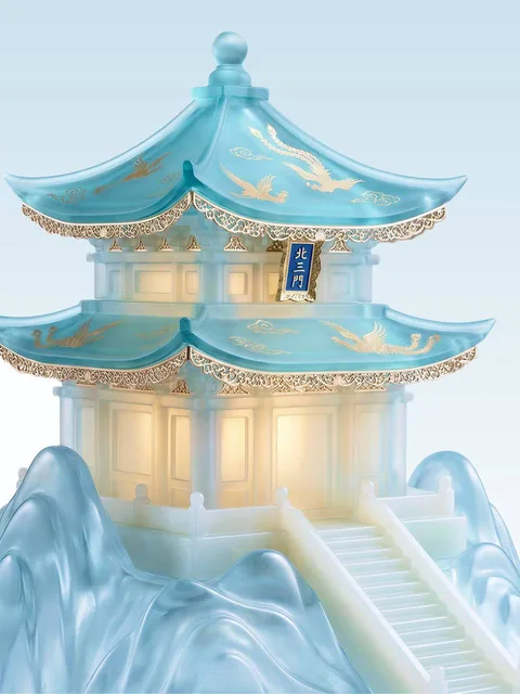 A highly detailed conceptual still life of an elegant traditional Chinese three-tiered pagoda pavilion made of semi-transparent jade-like glass in milky white and ice-blue tones, with turquoise-blue roofs and golden accents, glowing with warm inner light, standing on a sculptural mountain-water base