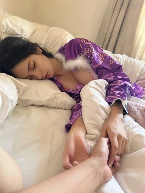 A boyfriend's perspective waking up in the morning, a Korean cosplayer dressed as Boa Hancock is sleeping while holding your hand, wearing pajamas, warm and intimate atmosphere, shot with an iPhone 17, not professionally taken.
