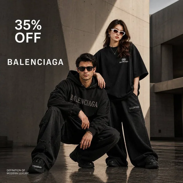 A high-fashion luxury advertisement for Balenciaga featuring a male and female model in oversized black streetwear against minimalist brutalist architecture with wet reflective ground, soft natural light, and strong shadows.