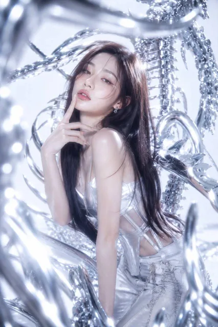 A world-class female K-pop idol with neo-futuristic Y2K aesthetic, elegant contrapposto pose, glass skin makeup, in a high-key studio with chrome biomechanical structures and blurred chrome foreground, Dutch tilt angle, 35mm editorial style.