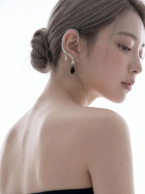 Extreme close-up high-key beauty editorial portrait of an elegant woman from behind, bare back and shoulder dominate foreground, side profile with silver ear cuff, cool pearl white studio backlight, soft overexposed highlights, film grain texture.
