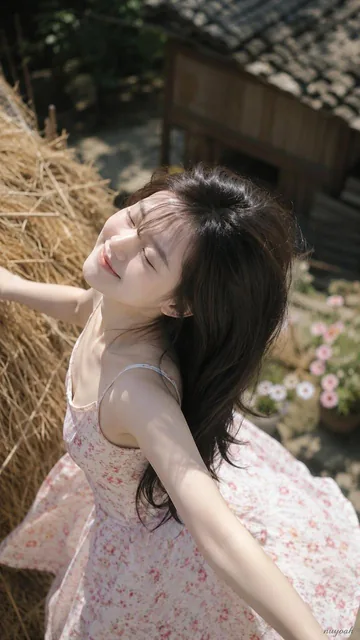 A young adult Chinese girl with black long hair and air bangs, wearing a suspender floral dress with cardigan design, in a dreamy spring pastoral setting with vintage wooden house, flower field, and soft sunlight, captured with telephoto lens in candid style.