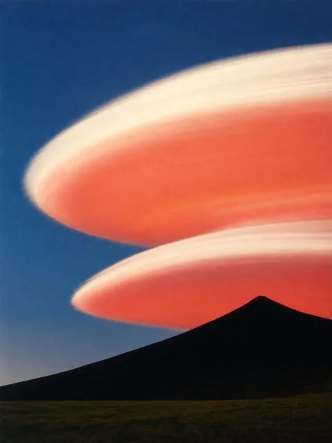 Minimalist analog photograph of a black volcanic mountain silhouette rising from a dark field into a deep blue sky, featuring two enormous, smooth, horizontally blurred lenticular