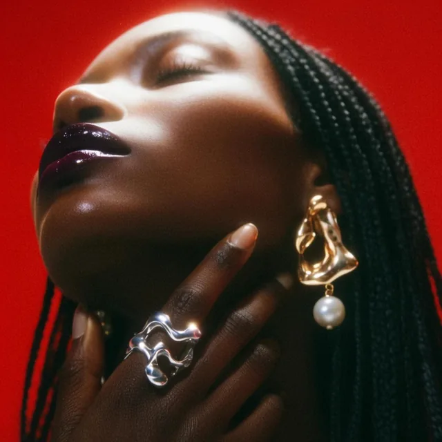 extreme close-up portrait of a dark-skinned woman with head tilted back, eyes closed, glossy da...