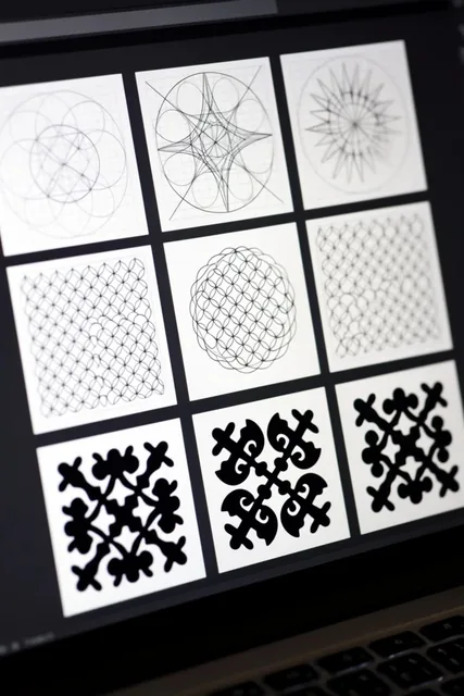 A close-up, angled view of a glowing laptop screen displaying a grid of nine square digital can...
