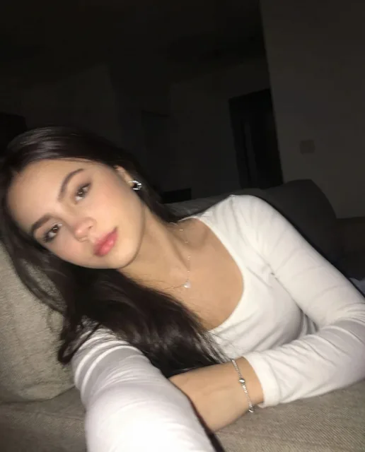 Using the uploaded reference photo, create a standard iPhone selfie with flash. There's n...