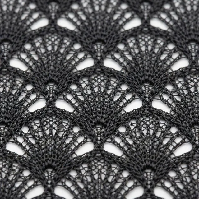 Extreme close-up macro photography of a double-layer black mesh fabric with a fan-shaped geometric pattern, showing the