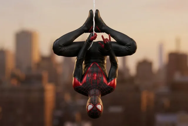 An upside-down human figure is suspended by a single vertical line, with their body curled inward, knees bent, and hands gripping the line above their head.