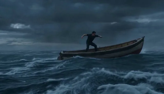 A lone man struggles to steady himself on a small boat in the middle of a violent ocean storm. Thunder cracks and heavy
