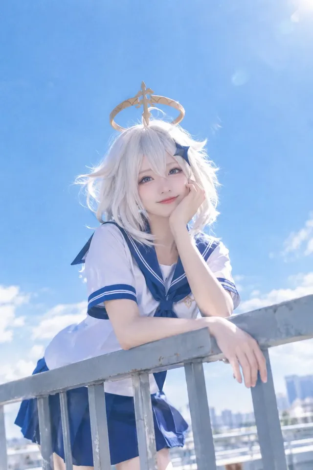 A female cosplayer in a Japanese school uniform leaning against a rooftop railing under a bright blue summer sky, with a cinematic film aesthetic.