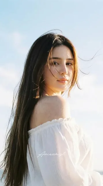 Portrait of a woman with ultra-long, sleek dark brown hair featuring sun-kissed highlights, gently blowing in the breeze, with luminous glowing edges and a soft, airy texture again