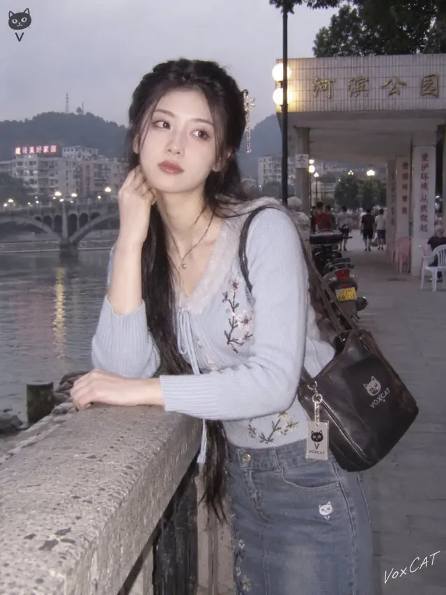 A young person in stylish early 2000s Chinese county town attire, posing with a vintage flip phone against a backdrop of typical street scenes and shops, captured with a distinct early digital camera look.