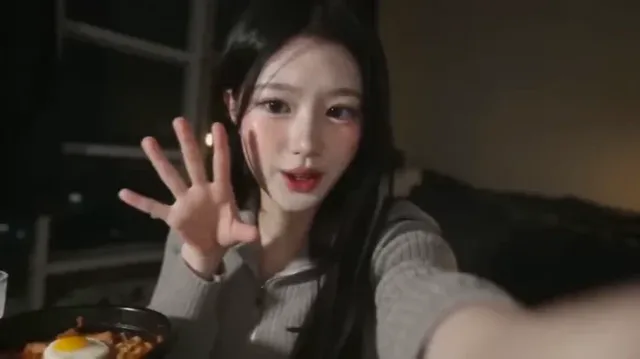POV shot of a Korean idol in a cozy dorm room at night, eating noodles and speaking softly into a shaky handheld DV camera, with soft, bloomy highlights and a retro film aesthetic.