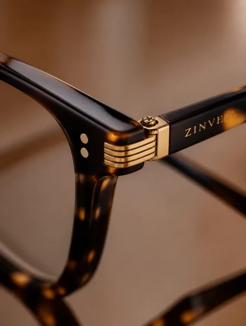 Extreme macro shot of luxury eyeglasses, focusing on the frame, hinges, and temples with soft, elegant lighting.