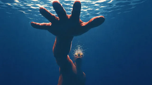 Low-angle view of a bald figure with glowing golden goggles and an oversized raised hand in a starry cosmos.