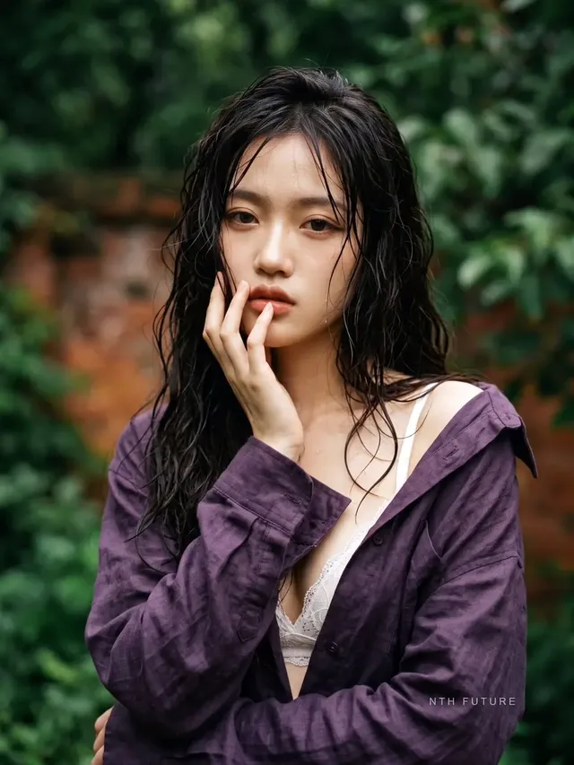 Close-up cinematic portrait of an ethereal Asian woman with wet hair and expressive eyes, surrounded by blurred green foliage.