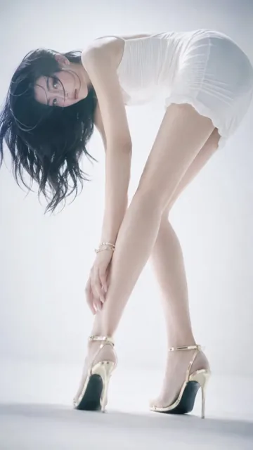 Low-angle shot of a fashion model's ankle and golden stiletto heel, with soft focus and ethereal lighting, emphasizing elegant leg lines and a chic pose.